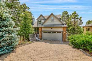 een huis met een garage en een oprit bij Whispering Pines in Flagstaff