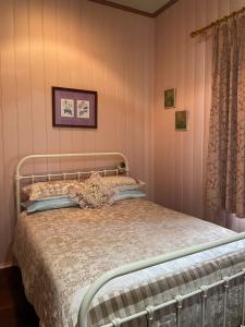 1 cama en un dormitorio con paredes rosas en Belvoir B&B Cottages, en Grafton