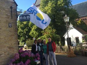 um grupo de pessoas em pé na frente de uma bandeira em De Thuiskamer in Grou als B&B of Vakantiehuis em Grou