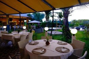 un restaurante con mesas blancas y sillas con luces en Barong Resort, en Ban Phe