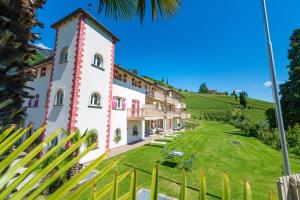 un edificio su una collina con un prato di Überbacherhof a Termeno