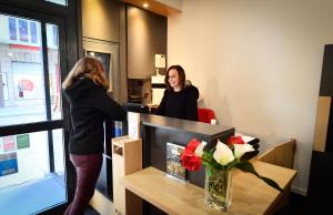 a woman is standing at a counter in a salon at B&B HOTEL Dijon Centre in Dijon