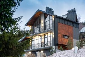 a house on a hillside with a balcony at Stara Pravda Villas in Bukovel