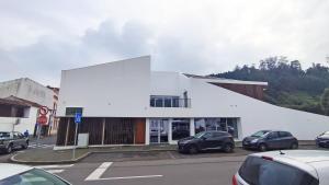 un edificio blanco con coches estacionados en un estacionamiento en Atlantic 3 Bicas - Furnas, en Furnas