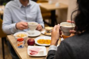 a group of people sitting at a table drinking coffee at Hôtel Le Florin in Rennes