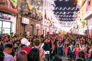 een grote menigte mensen die door een straat lopen bij Amplio y cómodo departamento. in Loja