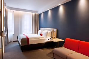 une chambre d'hôtel avec un lit et un canapé dans l'établissement Holiday Inn Express - Darmstadt, an IHG Hotel, à Darmstadt