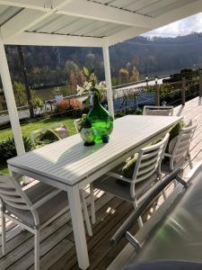 a white table with a green vase and two chairs at Villa Waulsort in Waulsort