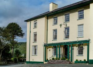 un grand bâtiment blanc avec des finitions vertes dans l'établissement Royal Victoria Hotel Snowdonia, à Llanberis