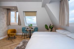 um quarto com uma cama, uma mesa e cadeiras em Hotel At Sea em Zandvoort