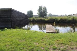 ein Holzsteg in der Mitte eines Flusses in der Unterkunft BakBoord in Grou