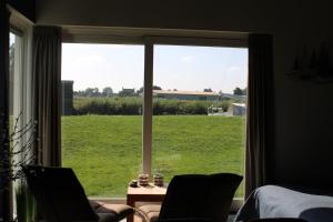 Zimmer mit einem großen Fenster mit Blick auf ein Feld in der Unterkunft BakBoord in Grou