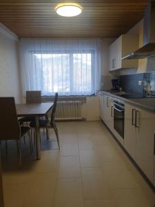 a kitchen with a table and chairs and a window at Ferien am Wald in Baiersbronn