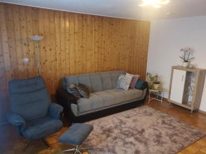 a living room with a couch and a chair at Ferien am Wald in Baiersbronn