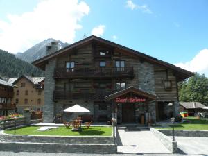 a large wooden building with a table in front of it at Hotel Bellevue in Champoluc