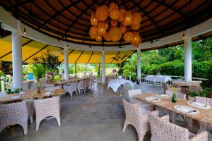 un restaurante con mesas y sillas y una lámpara de araña en Barong Resort, en Ban Phe