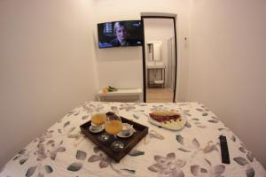 a bed with a tray of food and two glasses of orange juice at FP HOTELs in Alcalá de Henares