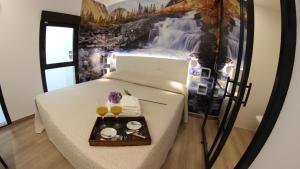 a room with a bed with a waterfall mural on the wall at FP HOTELs in Alcalá de Henares