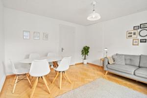 a living room with a table and chairs and a couch at Modern & Central Apartments in Luzern