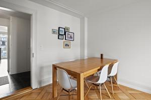 een eetkamer met een houten tafel en witte stoelen bij Central Bright & Cozy Apartments in Luzern