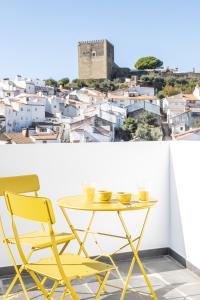 tavolo giallo e sedie con vista sulla città di A BURGUESA - GUESTHOUSE a Castelo de Vide