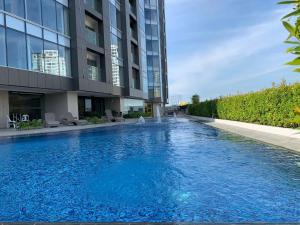 een groot zwembad voor een gebouw bij AEON SUITES STAYCATION managed by ARIA HOTEL in Davao City