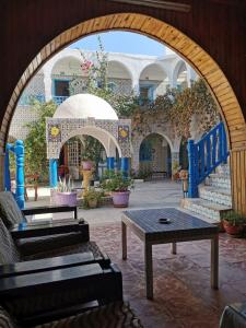 une arche avec une table et des chaises dans la cour dans l'établissement Hôtel Sindbad, à Houmt Souk