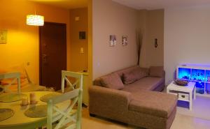 a living room with a couch and a tv at Dream house in Loutraki