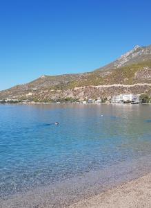 a beach with a person swimming in the water at Dream house in Loutraki