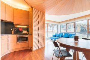 a kitchen and dining room with a table and blue chairs at Terrazza su Sestriere Lux in Sestriere