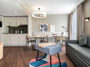 uma sala de estar com um sofá e uma mesa em Aparthotel Adagio Paris Suresnes Longchamp em Suresnes