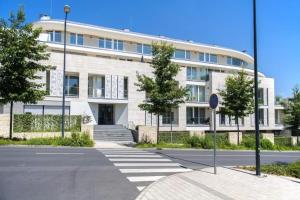 a large white building with a street sign in front of it at Spa Residence Carbona Royal Suites 1.11 in Hévíz