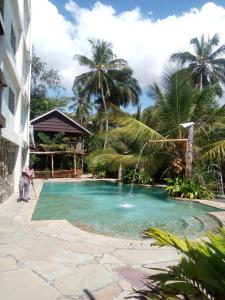 Un uomo in piedi vicino a una piscina in un resort di Ziwa Beach Resort a Bamburi