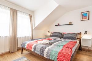 een slaapkamer met een bed met een kleurrijke quilt bij Penzion Quest in Loket