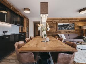 a kitchen and dining room with a wooden table and chairs at VAYA St Zeno Serfaus in Serfaus