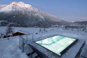 een zwembad met sneeuw en een berg bij Paramount Alma Suites in Sesto