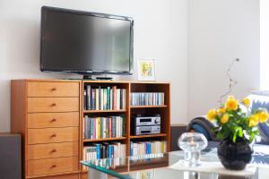 una sala de estar con TV en un estante de libros en Stadthaus Jürgensby, en Flensburg