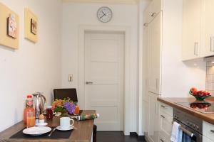 cocina con mesa y reloj en la pared en Stadthaus Jürgensby, en Flensburg