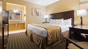 een hotelkamer met een groot bed en een bureau bij Best Western Green Tree Inn in Clarksville