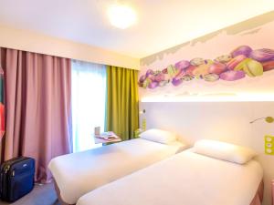 um quarto de hotel com duas camas e uma prateleira com fruta na parede em ibis Styles Fréjus St Raphael em Fréjus