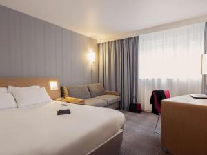 A bed or beds in a room at Novotel Roissy Saint Witz