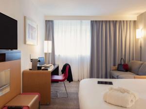 A bed or beds in a room at Novotel Roissy Saint Witz