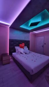 een slaapkamer met een groot bed met paarse verlichting bij RoyalSpa appartement d'amour avec jacuzzi privatif in Straatsburg