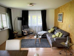 un soggiorno con divano e sedia di Ferienwohnung Hesselbach a Oberkirch