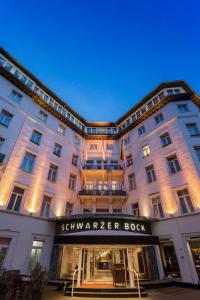 ein großes, weißes Gebäude mit einem Schild, das ein Buch liest in der Unterkunft Radisson Blu Hotel Schwarzer Bock Wiesbaden in Wiesbaden