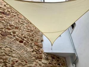 um edifício com toldo ao lado de uma parede de pedra em PUERTA DE CACERES Apartamento 2 em Cáceres