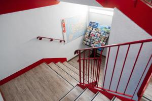 a staircase with a red railing and a refrigerator at Class'eco Charleroi in Charleroi