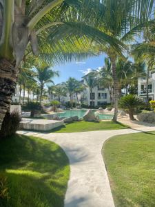 uma passagem através de um resort com palmeiras em Atmospheric apartment with a beautiful view of the swimming pool em Bayahibe