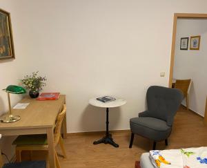 Habitación con escritorio, silla y mesa. en Ferienwohnung Zentrum, en Neuruppin