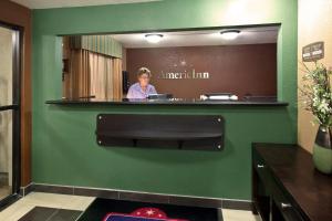 une femme dans un miroir dans une chambre d'hôtel dans l'établissement AmericInn by Wyndham Council Bluffs, à Council Bluffs